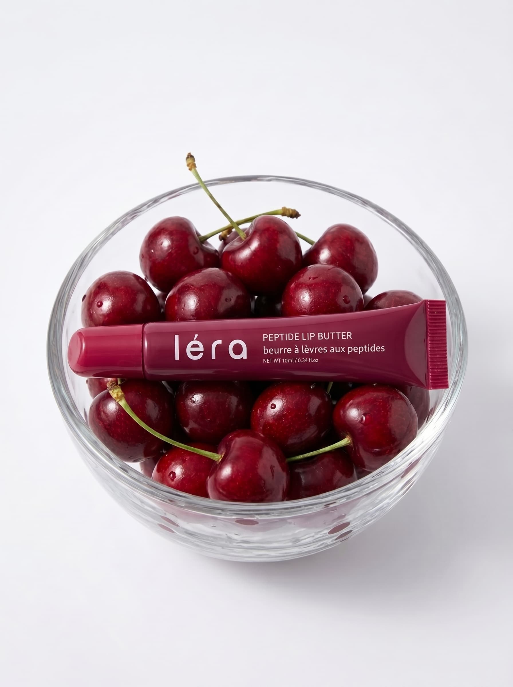 LÉRA Peptide Lip Butter – Cherry Kiss on a warm, sunlit surface